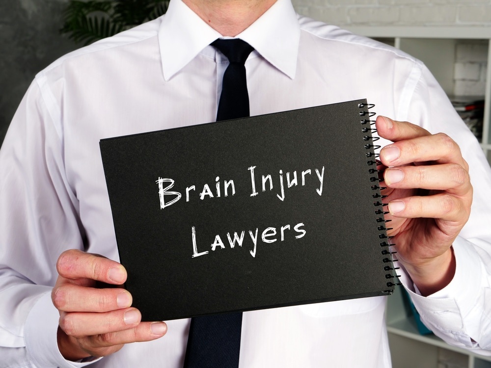 Man holding a paper that says Brain Injury Lawyers.