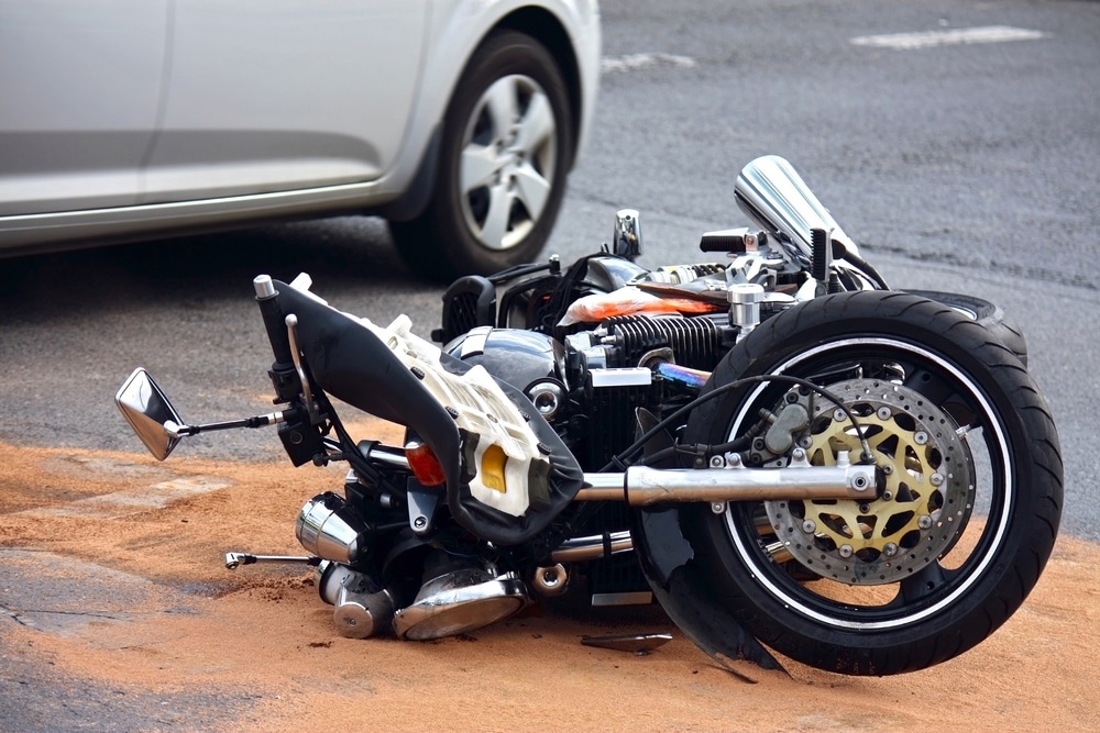 A crashed motorcycle on its side on the ground.