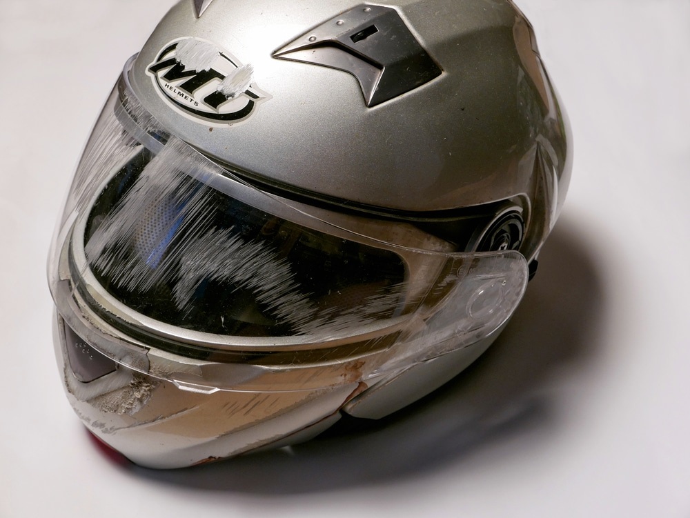 A scratched motorcycle helmet that has been in an accident.